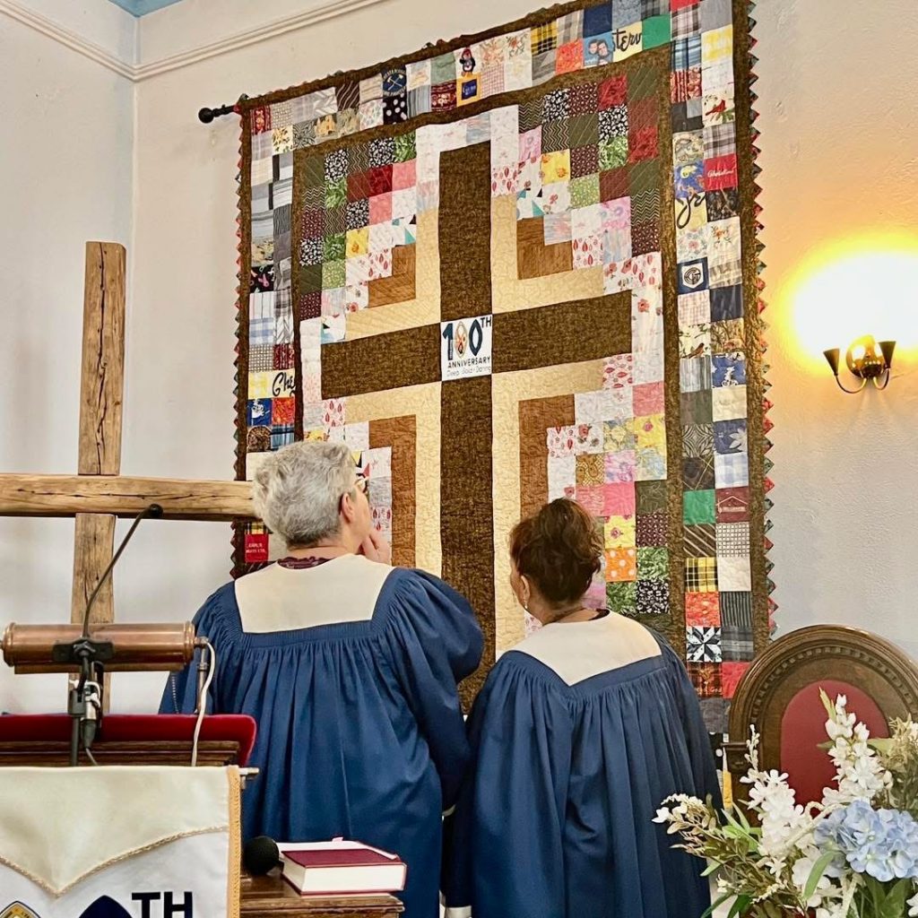 Gail and Maria looking at quilt.